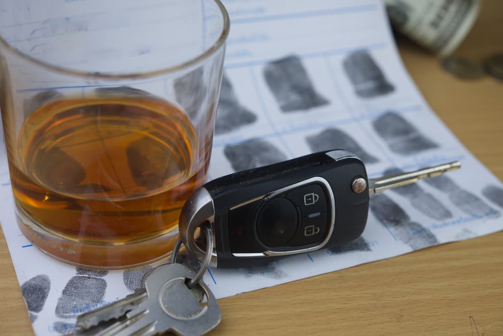 Glass and car key on police fingerprint crime page file.