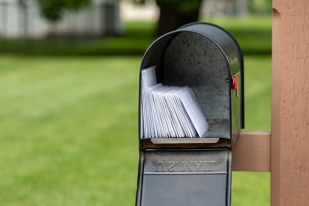 Mailbox full of letters and junk mail.